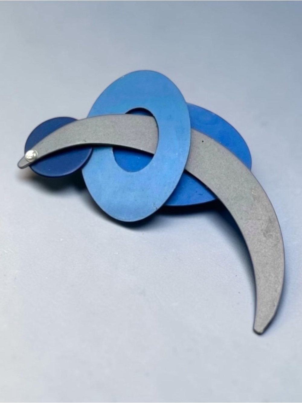 EROS by Q3 Abstract Oxidized Aluminum Dolphin Jumping Hoop Statement Brooch